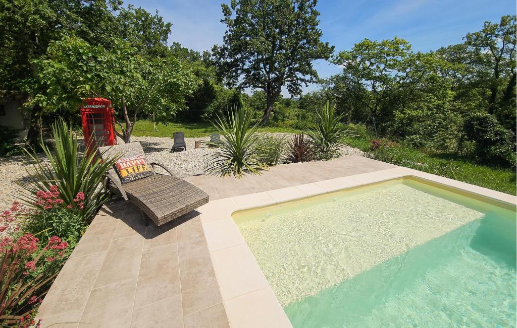 une piscine avec un banc et une chaise à côté dans l'établissement 3 Bedroom Beautiful Home In Barjac, à Barjac