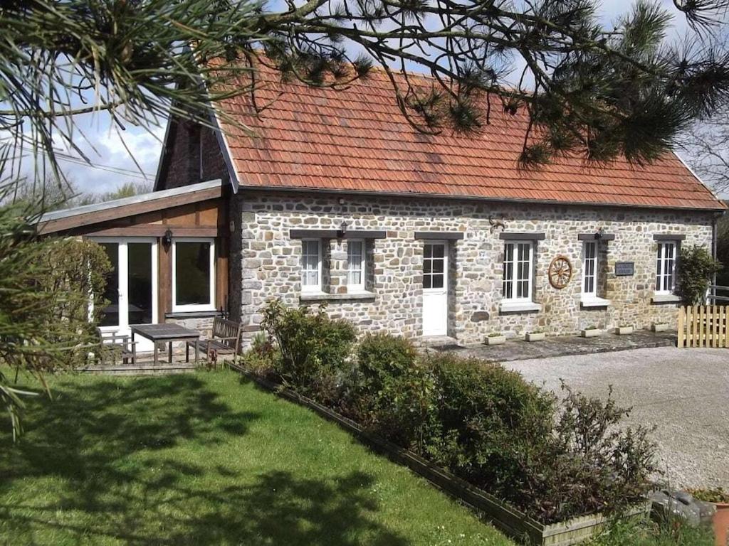 une petite maison en pierre avec un toit rouge dans l'établissement Holiday home with 3 bedrooms, à Neufmesnil