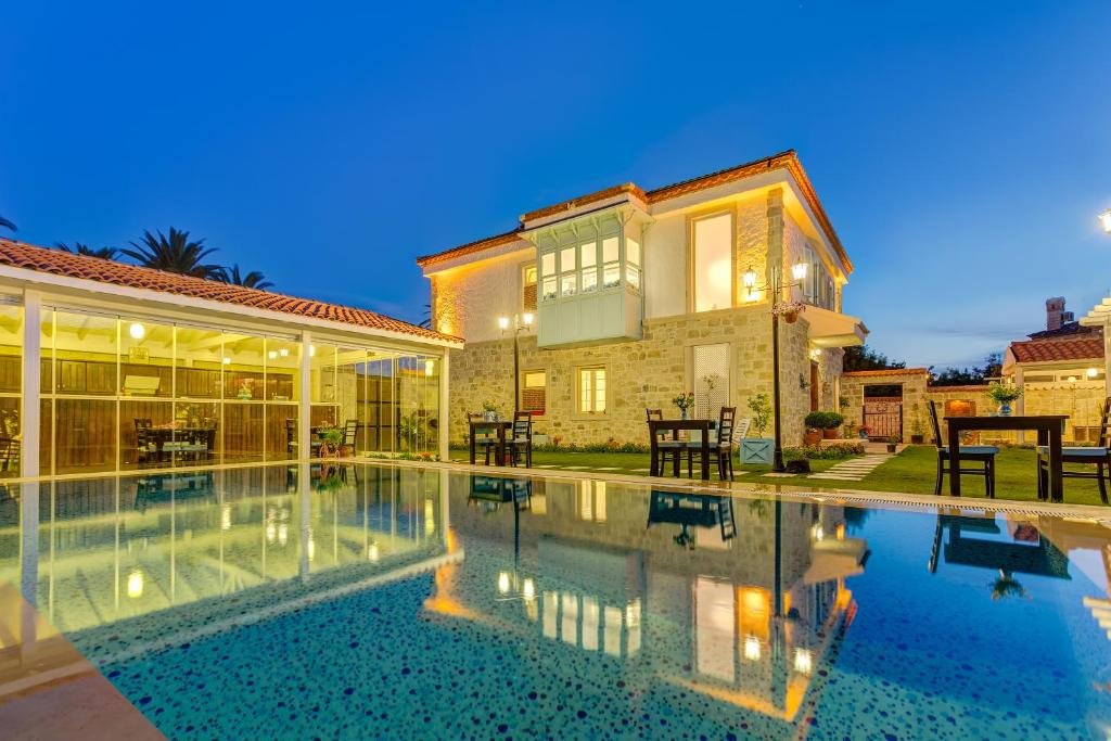 a villa with a swimming pool at night at BELLAPİETRA Hotel in Alaçatı