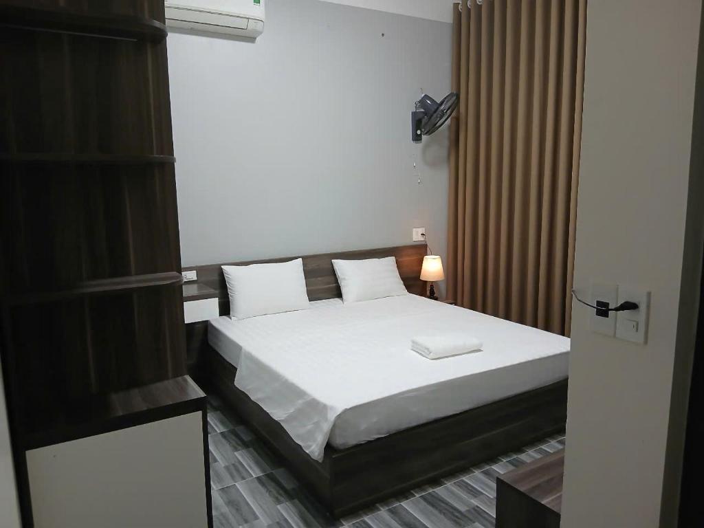 een slaapkamer met een bed met witte lakens bij GolDen RiCe in Thái Thụy