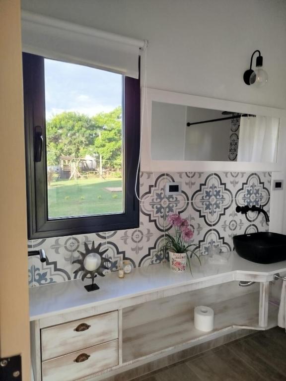 a bathroom with a window and a counter with a mirror at Portal del Lago - Casa confortable cerca del lago - Hermoso atardecer in Federación
