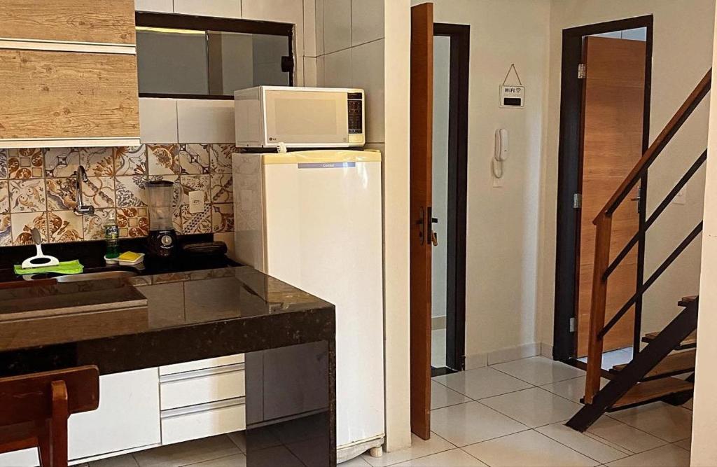een keuken met een magnetron en een koelkast bij Loft Lampião in Campina Grande