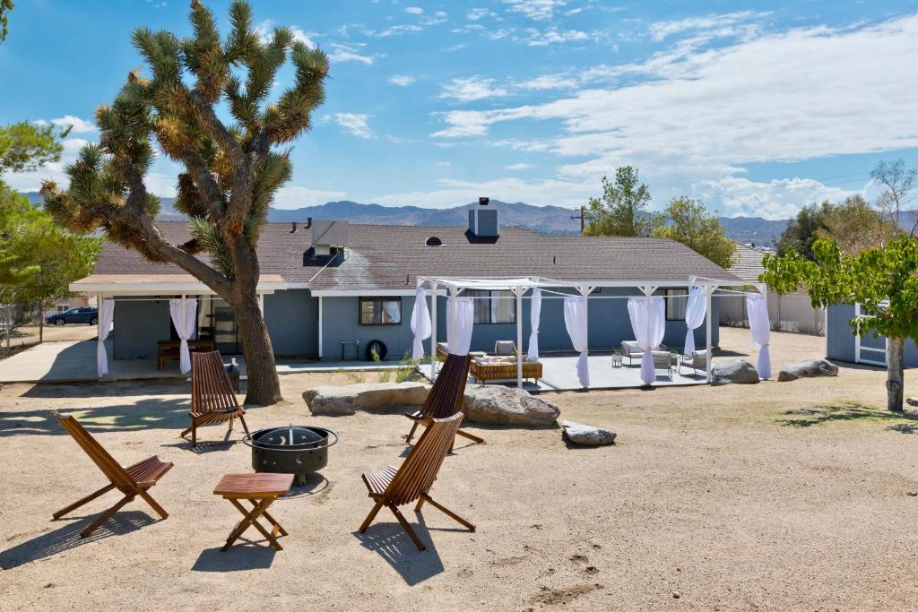 a group of chairs sitting in front of a house at Desert Dream Oasis - Spa, Cabana, Firepit, Disney and Hulu in Yucca Valley