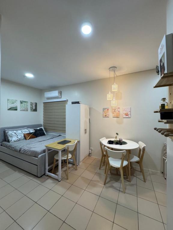 Un dormitorio con una cama y una mesa y sillas. en Tiny's BnB, en Davao City