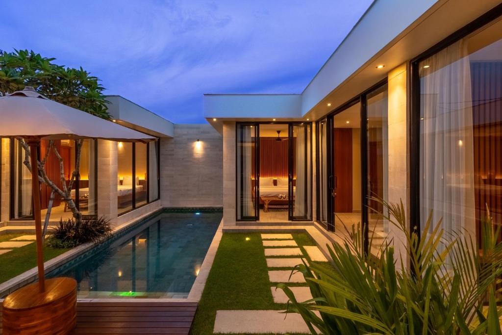 an external view of a house with a swimming pool at Solencia Villa by Betterplace in Jimbaran