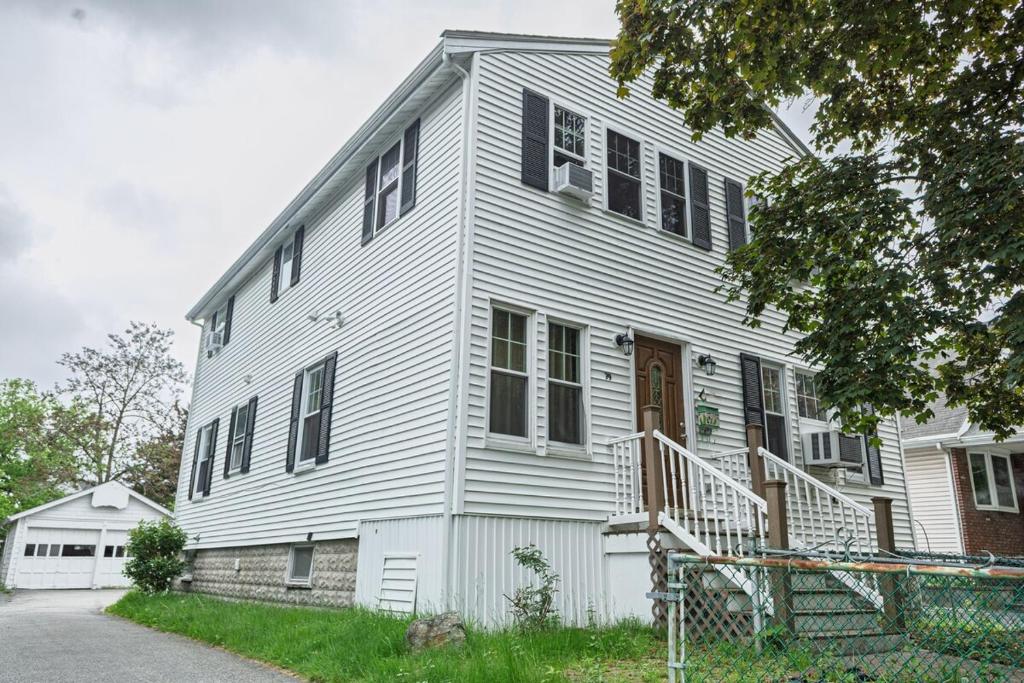 a white house with black shutters on it at Extremely Spacious Home 10 Mins to The Encore in Medford