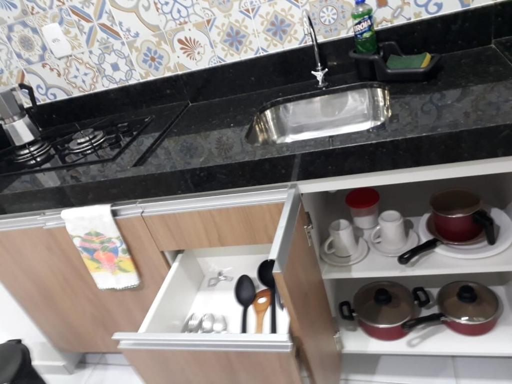 eine Miniaturküche mit einer Spüle und einer Theke in der Unterkunft Loft Marinês in Campina Grande