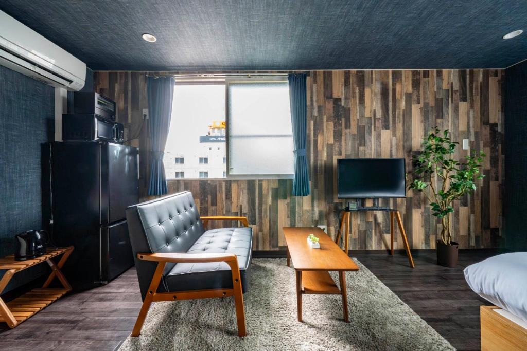 a room with a bed and a couch and a tv at Silk Court 405 in Chitose