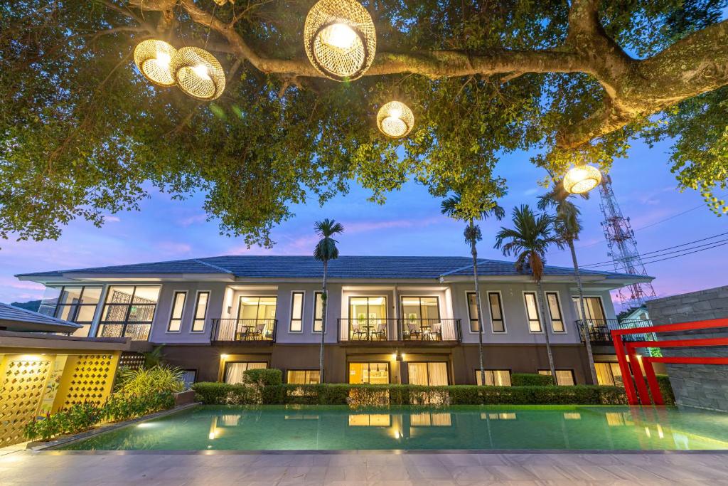 an exterior view of a house with a pool at Antiya Hotel Phuket in Phuket Town