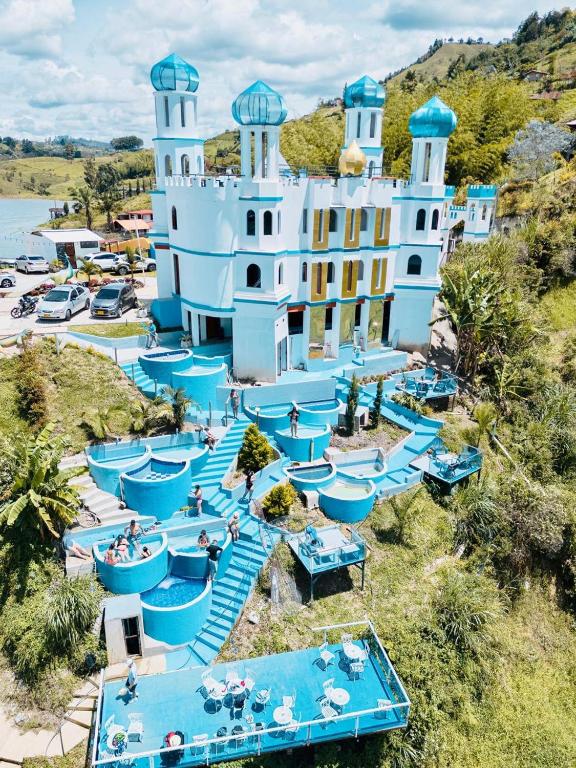 an aerial view of a resort with blue tables at Hotel y Termales Castillo Del Lago Guatape in Horizonte