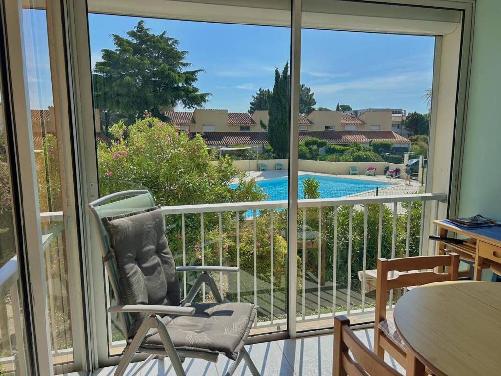 d'un balcon avec une chaise et une vue sur la piscine. dans l'établissement Charmant T2 à Argelès-sur-Mer avec Terrasse et Parking - FR-1-388-242, à Argelès-sur-Mer