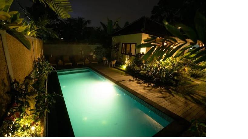 una piscina con luces en un patio trasero por la noche en Villa Pondok Sadia, en Tegalalang