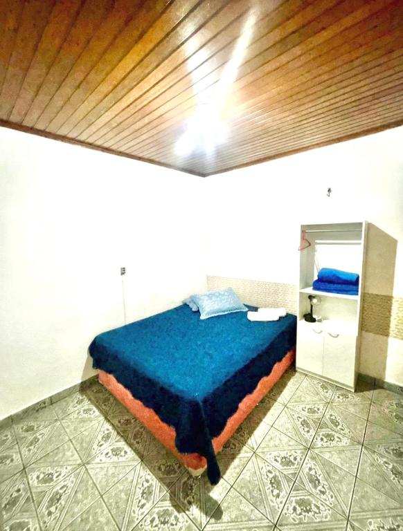 a bedroom with a blue bed in a room at Ap espaçoso prox aeroporto in Manaus