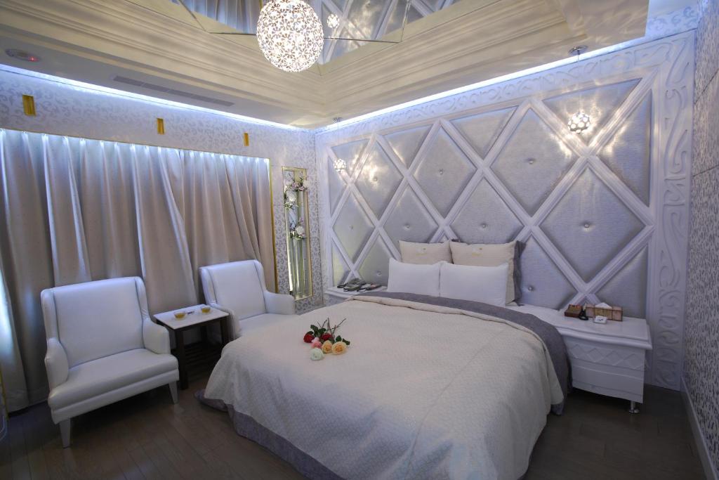 um quarto com uma cama grande e 2 cadeiras em Lai Yin Motel em Longtan