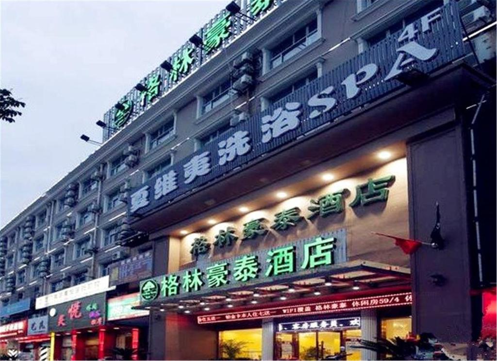 a building with neon signs on the side of it at GreenTree Inn ShangHai SongJiang SongDong Business Hotel in Songjiang