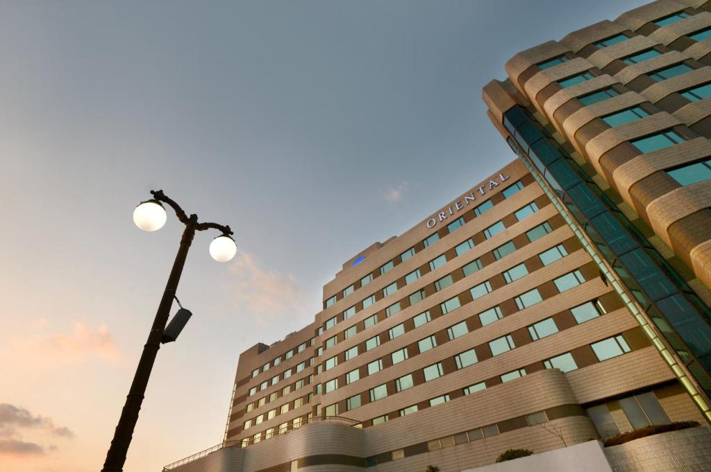 wysoki budynek z światłem ulicznym przed nim w obiekcie Jeju Oriental Hotel & Casino w mieście Czedżu