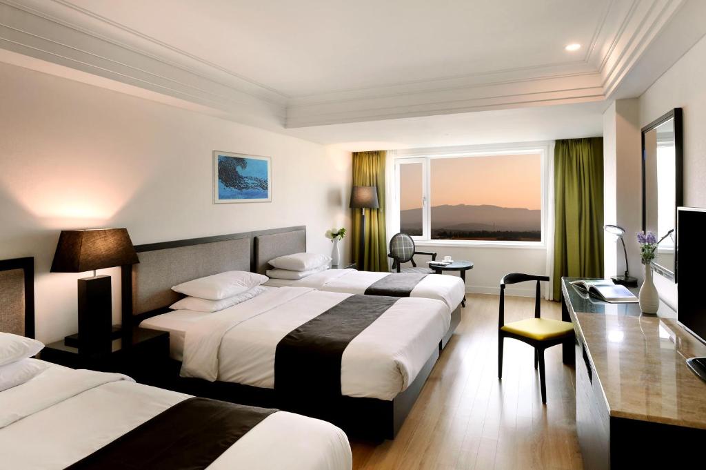Postel nebo postele na pokoji v ubytování Jeju Oriental Hotel & Casino
