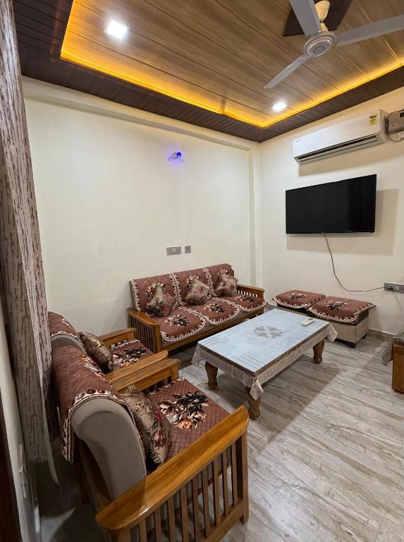 a living room with couches and a flat screen tv at Luxury Appartment Radha Kunj in Vrindāvan