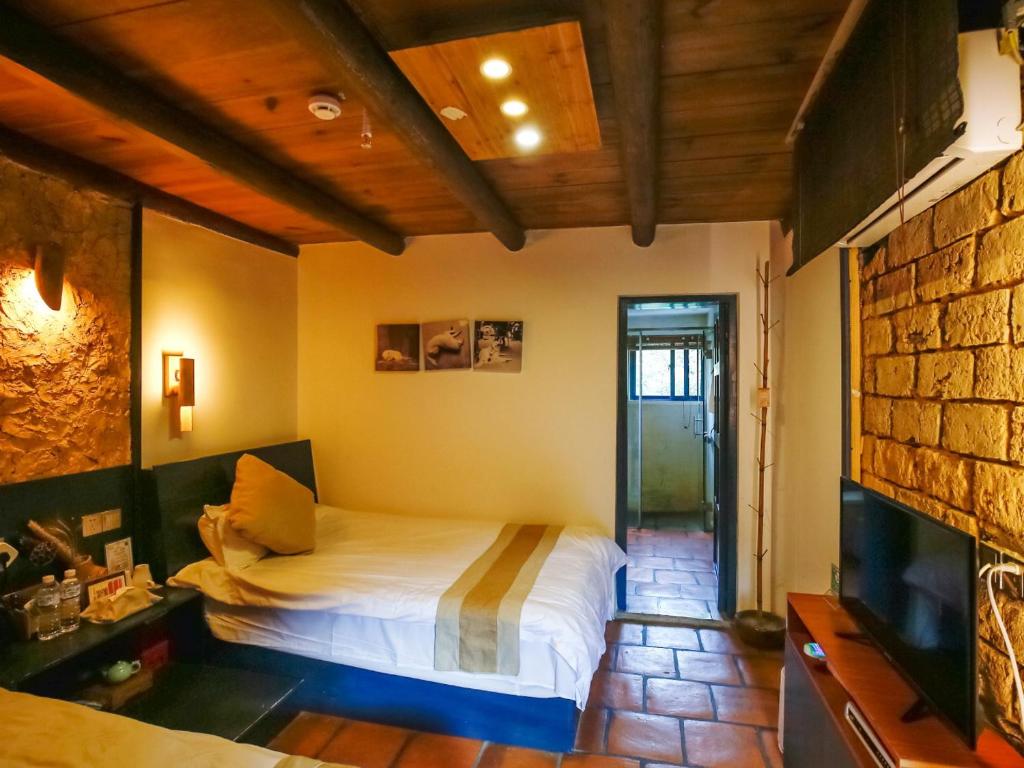 Postel nebo postele na pokoji v ubytování Tulou Herongzhuang Inn