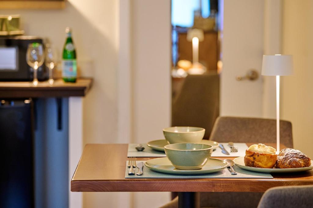 a table with three cups and plates of food on it at Liahona Guest House in Ucluelet