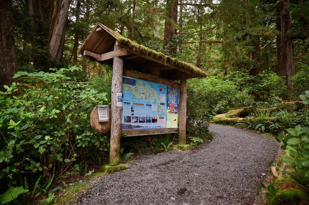 a sign on the side of a trail at Liahona Guest House in Ucluelet