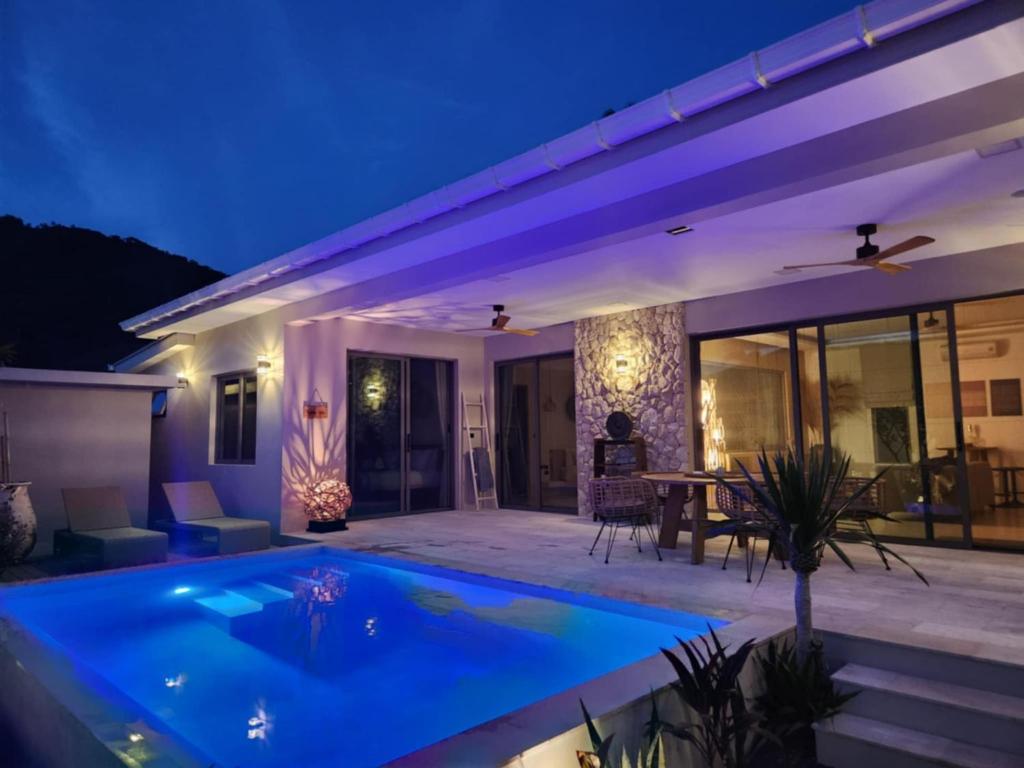 a villa with a swimming pool at night at Karleya residence in Nathon Bay