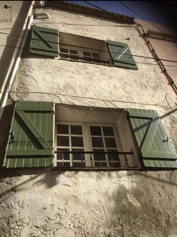 une fenêtre avec volets verts dans un bâtiment dans l'établissement Maison de village atypique, à Cuers