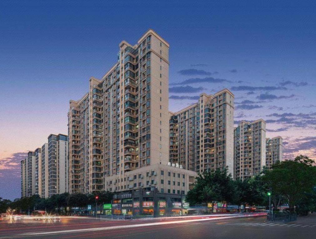 a large apartment building with a street in front of it at Xana Hotelle Xiamen Airport Zone Government in Xiamen