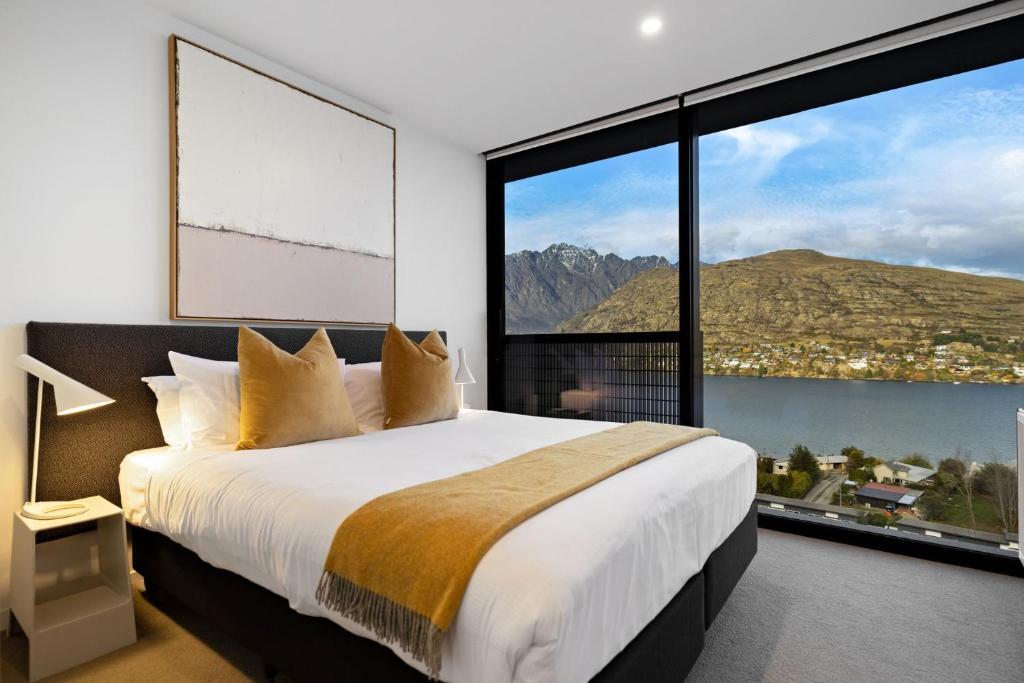 a bedroom with a large bed and large windows at The Bunker Alpha B in Queenstown