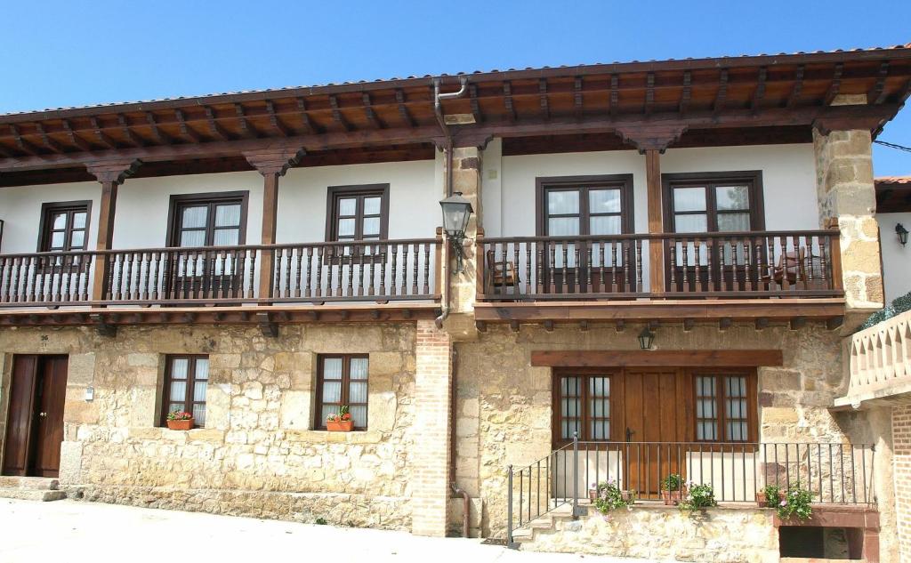 Casa de piedra antigua con balcón en la parte superior en Apartamentos LLave de Santillana, en Santillana del Mar