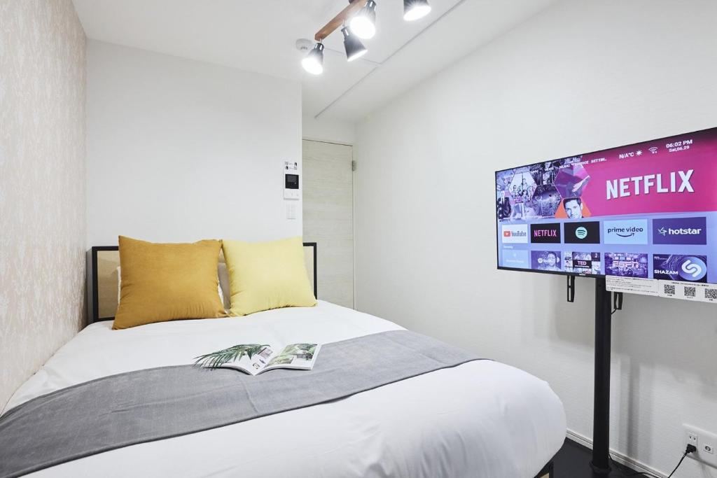 a bedroom with a bed with a tv on the wall at THE Dorchester β in Tokyo