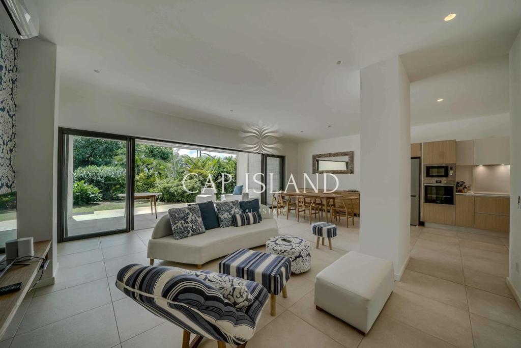 a living room with a couch and chairs and a kitchen at Garden level apartment, beach 8min walk in Grand Baie