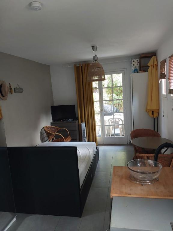 une chambre avec un lit, une table et une fenêtre dans l'établissement Studio avec jardin proche plages saint clair Lavandou, au Lavandou