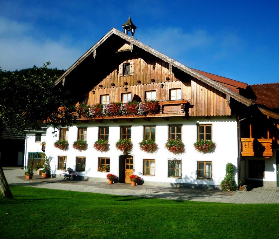 ein großes Holzgebäude mit Blumenkästen auf der Vorderseite in der Unterkunft Schmiedbauernhof in Fuschl am See