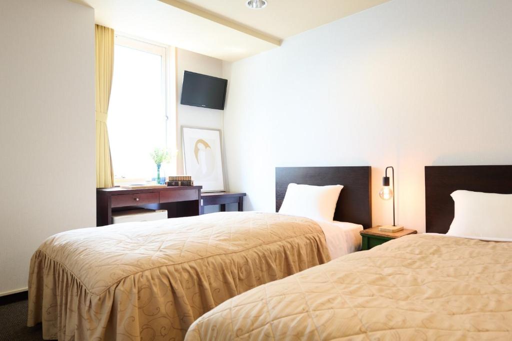 a hotel room with two beds and a window at Hotel Sho Sapporo - Vacation STAY 61073v in Sapporo