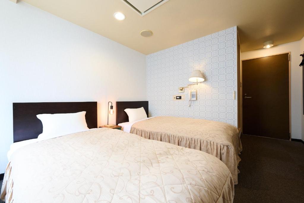 札幌市にあるHotel Sho Sapporo - Vacation STAY 61077vの部屋にベッドが2つあるホテルの部屋