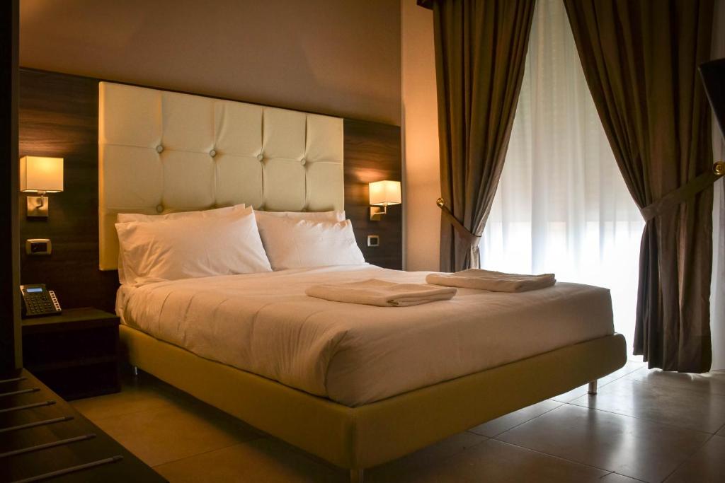 una camera da letto con un grande letto con una grande finestra di Brain Rooms & Suite a Pagani
