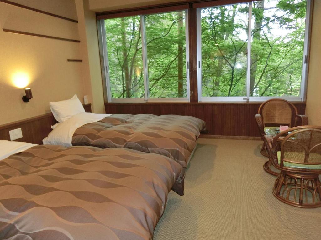 Postel nebo postele na pokoji v ubytování Kusatsu Skyland Hotel