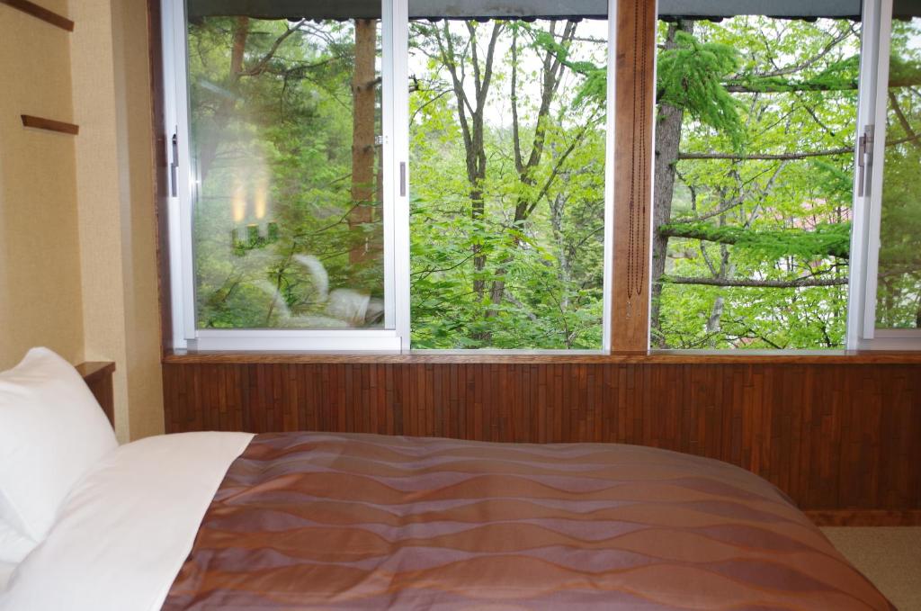 Postel nebo postele na pokoji v ubytování Kusatsu Skyland Hotel