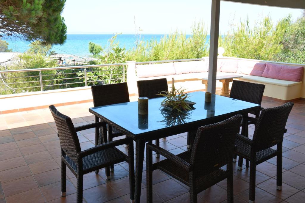 una mesa y sillas con vistas al océano en Villa Basta, en Vasilikos