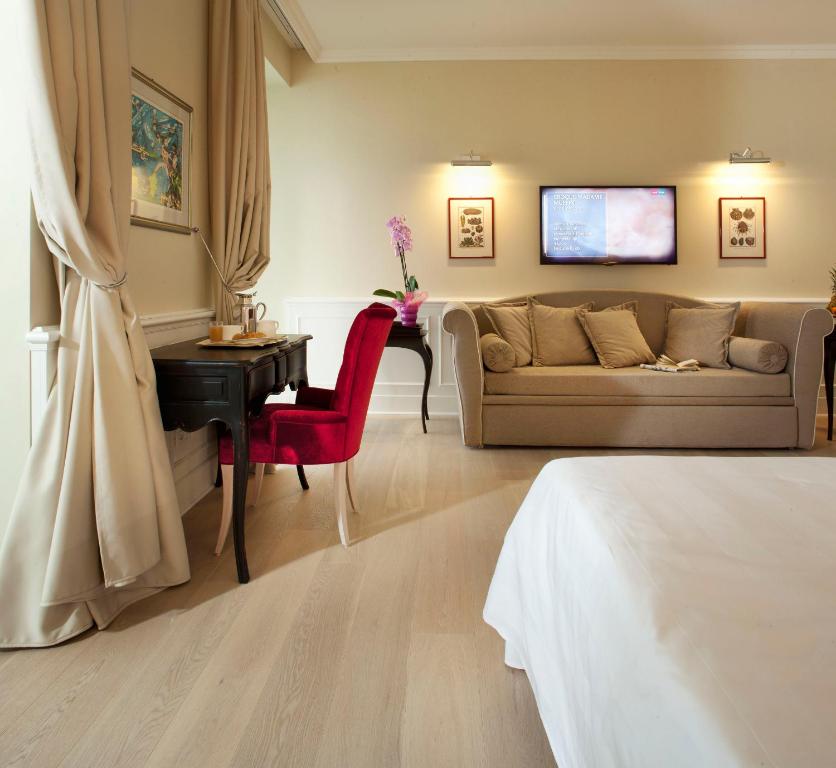 a living room with a couch and a table at Hotel Riviera & Maximilian's in Trieste