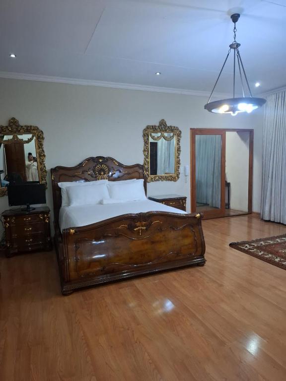 a bedroom with a wooden bed and two mirrors at Aaybee for Four in Midrand