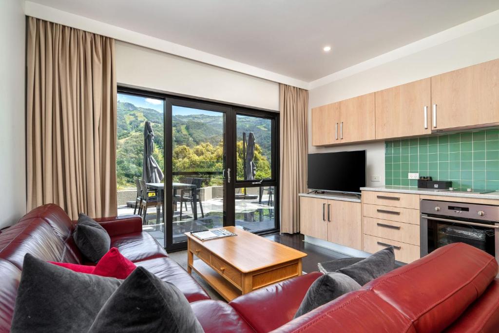 a living room with a couch and a table at Lantern 13 - Deluxe Terrace in Thredbo