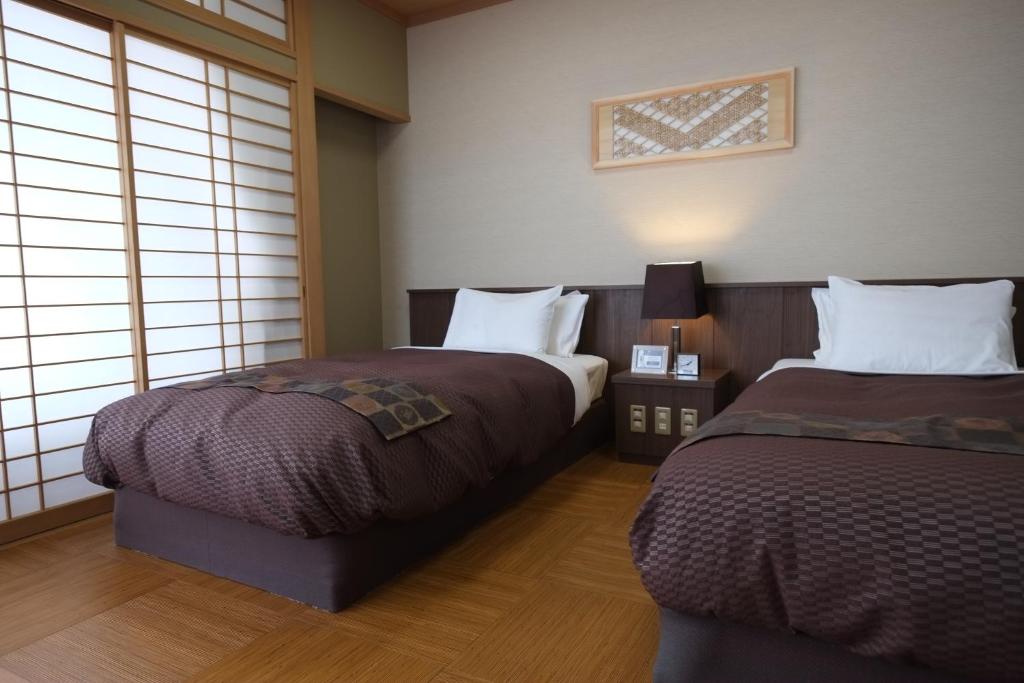 Postel nebo postele na pokoji v ubytování Nikko Senhime Monogatari