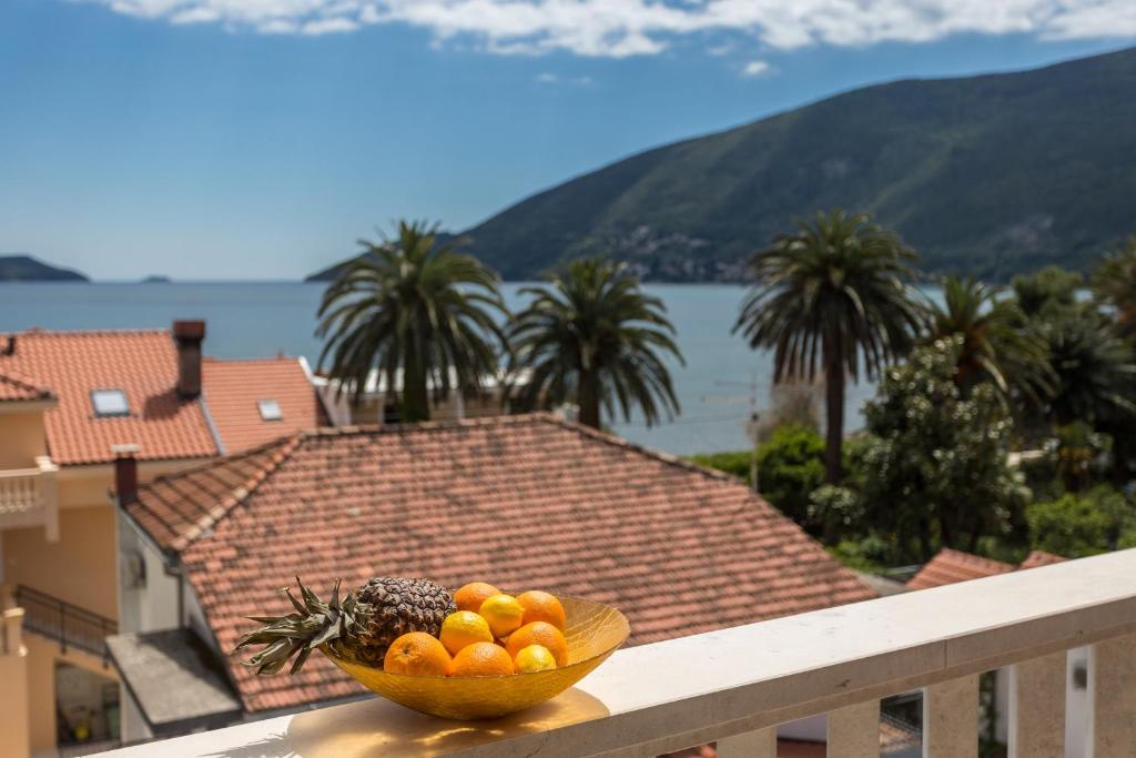 a bowl of fruit on a balcony with a view at Grifone Igalo in Herceg-Novi