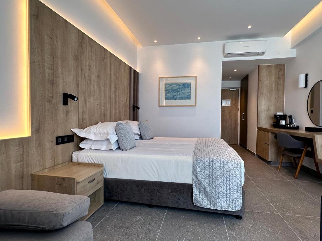 a bedroom with a large bed and a desk at Sofianna Resort & Spa in Paphos