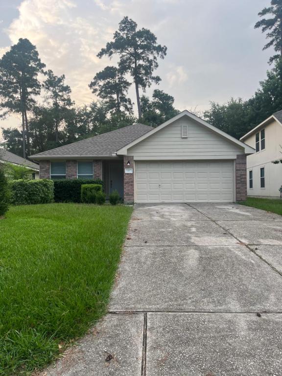 a house with a white garage in a yard at Spacious 3 bed/ 2 bathroom House in Conroe, TX in Conroe
