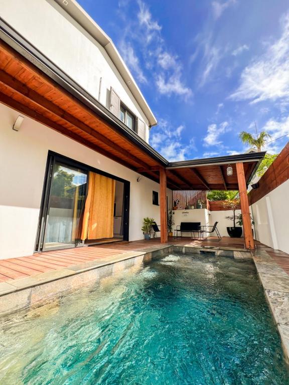 a swimming pool in the backyard of a house at La Ŵilla, piscine et parking privatisées, accès mer, sentiers et volcans!! in Saint-Joseph