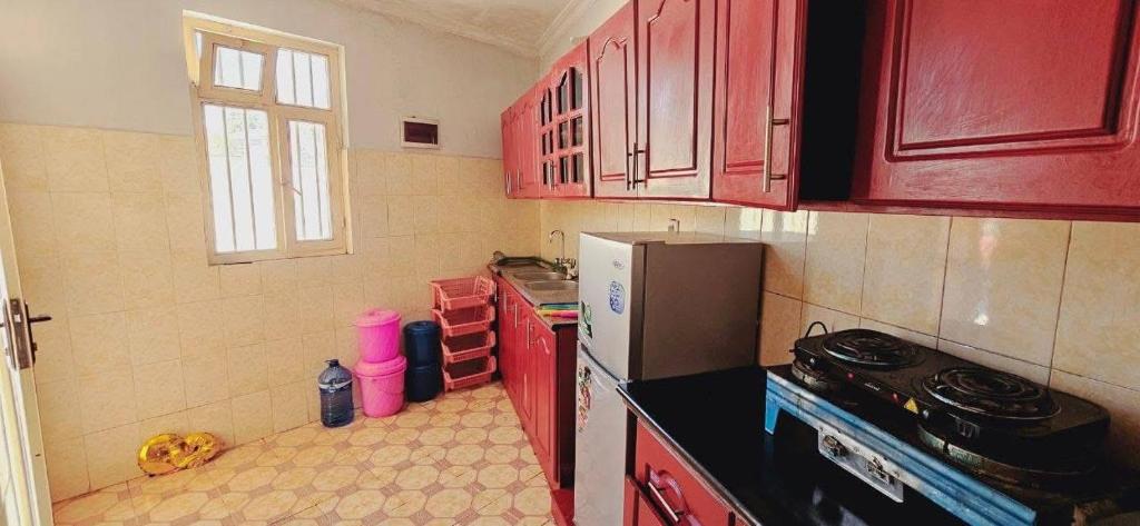 a kitchen with red cabinets and a black counter top at Rahma furnished apartment 2 in Addis Ababa