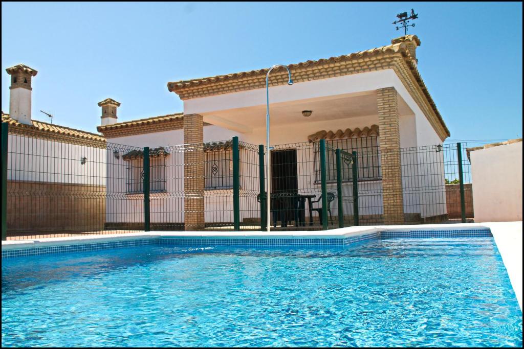 una piscina frente a una casa en Chalet Arroyo Majadales 107, en Conil de la Frontera